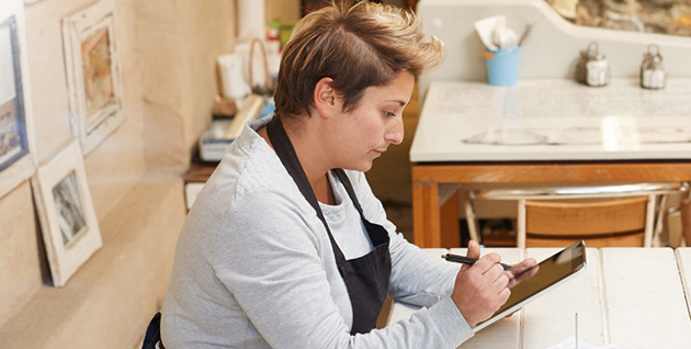 woman working on tablet at her shop